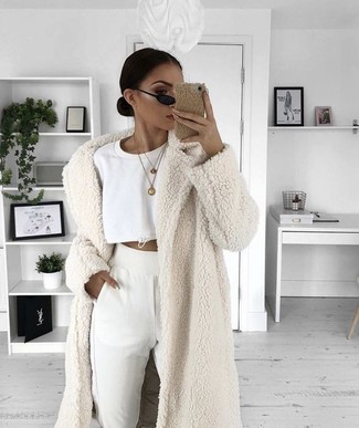 Winter Outfits Damen 2024: Erwägen Sie das Tragen von einem weißen Pelz und einer weißen Jogginghose für eine entspannte Silhouette. Schon ergibt sich ein cooles Winter-Outfit.