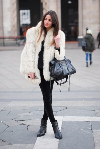 Winter Outfits Damen 2024: Probieren Sie die Kombination aus einem weißen Pelz und schwarzen engen Jeans, um einen verfeinerten Casual-Look zu kreieren, der in der Garderobe der Frau auf keinen Fall fehlen darf. Schwarze Leder Stiefeletten sind eine perfekte Wahl, um dieses Outfit zu vervollständigen. Dieses Outfit ist perfekt für den Winter.