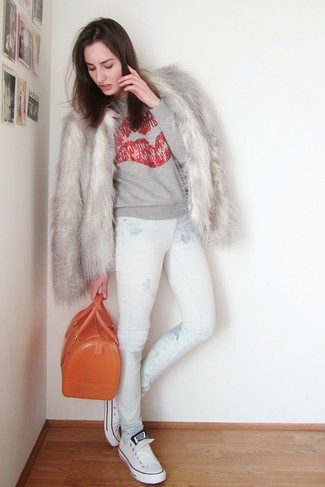 graue Pelzjacke, grauer bedruckter Pullover mit einem Rundhalsausschnitt, weiße bedruckte enge Jeans, weiße niedrige Sneakers für Damen