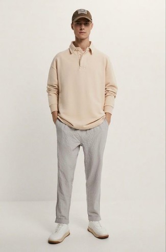 hellbeige Polo Pullover, graue Chinohose aus Seersucker, weiße Leder niedrige Sneakers, braune bedruckte Baseballkappe für Herren