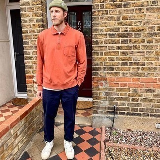 Herren Outfits 2021: Kombinieren Sie einen orange Polo Pullover mit einer dunkelblauen Chinohose, wenn Sie einen gepflegten und stylischen Look wollen. Fühlen Sie sich ideenreich? Wählen Sie weißen hohe Sneakers aus Segeltuch.