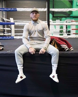 Conor McGregor trägt hellbeige Polohemd, graue Jogginghose, weiße Leder niedrige Sneakers, hellbeige Baseballkappe