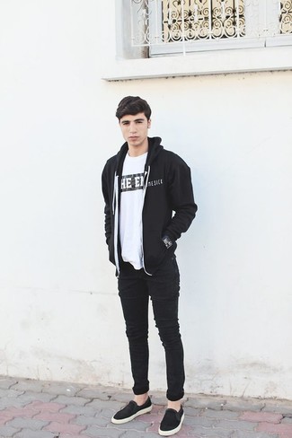 schwarzer Pullover mit einem Kapuze, weißes und schwarzes bedrucktes T-Shirt mit einem Rundhalsausschnitt, schwarze enge Jeans, schwarze Slip-On Sneakers für Herren
