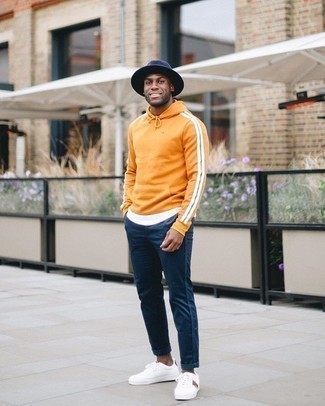Bedruckte Schuhe aus Segeltuch kombinieren – 618+ Herren Outfits: Entscheiden Sie sich für einen orange Pullover mit einem Kapuze und eine dunkelblaue Chinohose, um einen lockeren, aber dennoch stylischen Look zu erhalten. Weiße bedruckte Segeltuch niedrige Sneakers sind eine gute Wahl, um dieses Outfit zu vervollständigen.