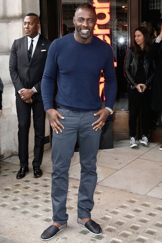 Idris Elba trägt dunkelblauer Pullover mit einem Rundhalsausschnitt, graue Chinohose, schwarze Leder Espadrilles, schwarzer Ledergürtel