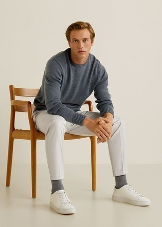 dunkelblauer Pullover mit einem Rundhalsausschnitt, weiße Chinohose, weiße Segeltuch niedrige Sneakers, graue Socken für Herren