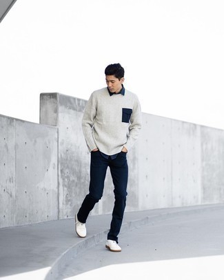 Dunkelgrauen Pullover mit einem Rundhalsausschnitt kombinieren – 500+ Herren Outfits: Vereinigen Sie einen dunkelgrauen Pullover mit einem Rundhalsausschnitt mit dunkelblauen Jeans für einen bequemen Alltags-Look. Dieses Outfit passt hervorragend zusammen mit weißen Segeltuch niedrigen Sneakers.