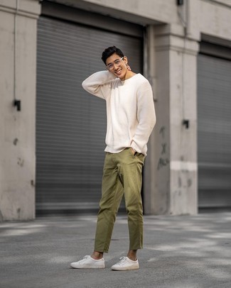 Hellbeige Pullover mit einem Rundhalsausschnitt kombinieren – 500+ Herren Outfits: Kombinieren Sie einen hellbeige Pullover mit einem Rundhalsausschnitt mit einer olivgrünen Chinohose für ein großartiges Wochenend-Outfit. Fühlen Sie sich ideenreich? Komplettieren Sie Ihr Outfit mit weißen Segeltuch niedrigen Sneakers.