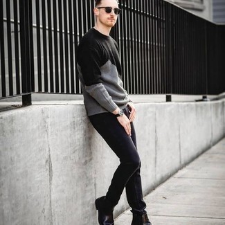 grauer Pullover mit einem Rundhalsausschnitt, schwarze Jeans, schwarze Chelsea Boots aus Leder, schwarze Sonnenbrille für Herren
