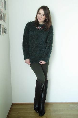 dunkelgrüner flauschiger Pullover mit einem Rundhalsausschnitt, dunkelgrüne Leggings, schwarze kniehohe Stiefel aus Leder, dunkelrote Halskette für Damen
