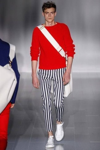 roter Pullover mit einem Rundhalsausschnitt, schwarze und weiße vertikal gestreifte Chinohose, weiße niedrige Sneakers, weiße Segeltuch Umhängetasche für Herren