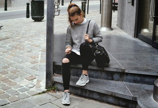 grauer Pullover mit einem Rundhalsausschnitt, weißes T-Shirt mit einem Rundhalsausschnitt, schwarze enge Jeans mit Destroyed-Effekten, graue Sportschuhe für Damen