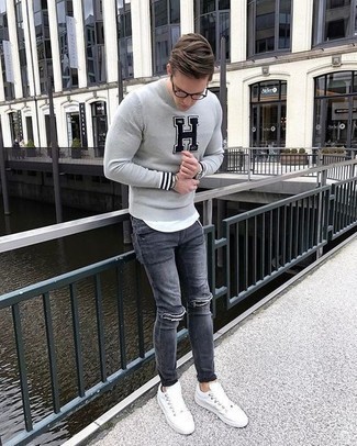20 Jährige: Dunkelgraue Jeans kombinieren – 233 Frühling Herren Outfits: Kombinieren Sie einen grauen bedruckten Pullover mit einem Rundhalsausschnitt mit dunkelgrauen Jeans für einen entspannten Wochenend-Look. Vervollständigen Sie Ihr Look mit weißen Segeltuch niedrigen Sneakers. Was für eine super Übergangs-Look Idee!