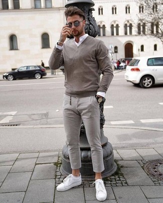 Grauen Pullover mit einem V-Ausschnitt kombinieren – 154 Herren Outfits: Kombinieren Sie einen grauen Pullover mit einem V-Ausschnitt mit einer grauen Chinohose für ein großartiges Wochenend-Outfit. Suchen Sie nach leichtem Schuhwerk? Wählen Sie weißen Leder niedrige Sneakers für den Tag.