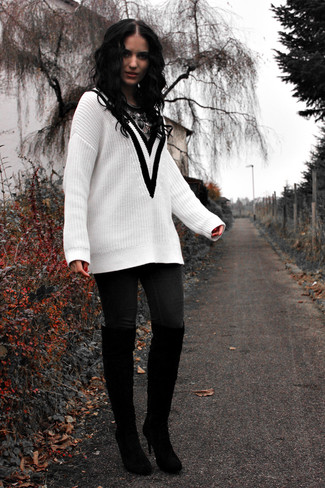 weißer und schwarzer Pullover mit einem V-Ausschnitt, schwarze enge Jeans, schwarze Overknee Stiefel aus Wildleder, silberne Halskette für Damen