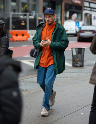 dunkelgrüne Regenjacke, orange Flanell Langarmhemd, blaue Jeans, hellbeige Sportschuhe für Herren