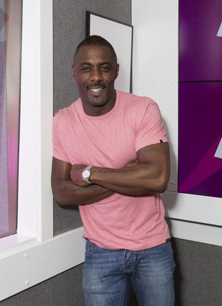 Idris Elba trägt rosa T-Shirt mit einem Rundhalsausschnitt, blaue Jeans, silberne Uhr