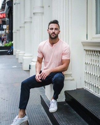 rosa T-Shirt mit einem V-Ausschnitt, dunkelblaue Chinohose, weiße Leder niedrige Sneakers für Herren