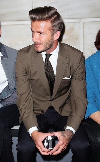 David Beckham trägt braunes Sakko, weißes Businesshemd, dunkelblaue Anzughose, dunkelbraune gepunktete Krawatte