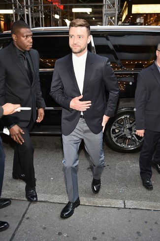 Justin Timberlake trägt schwarzes Sakko, weißes Businesshemd, graue Anzughose mit Karomuster, schwarze verzierte Leder Derby Schuhe
