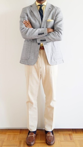 Braune Leder Slipper kombinieren – 1200+ Herren Outfits: Erwägen Sie das Tragen von einem grauen Sakko und einer hellbeige Anzughose für einen stilvollen, eleganten Look. Braune Leder Slipper sind eine gute Wahl, um dieses Outfit zu vervollständigen.