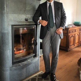 Graue Wollanzughose kombinieren – 500+ Herren Outfits: Entscheiden Sie sich für einen klassischen Stil in einem dunkelgrauen Wollsakko und einer grauen Wollanzughose. Dunkelbraune Leder Slipper sind eine perfekte Wahl, um dieses Outfit zu vervollständigen.