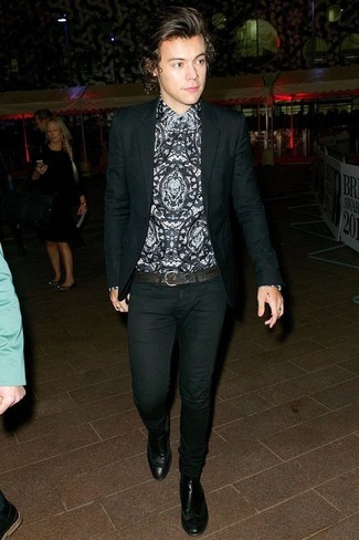 Harry Styles trägt schwarzes Sakko, graues bedrucktes Businesshemd, schwarze enge Jeans, schwarze Chelsea-Stiefel aus Leder