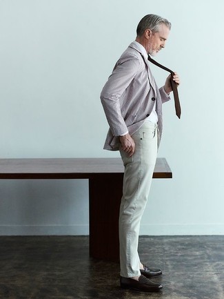 Herren Outfits 2022: Kombinieren Sie ein braunes vertikal gestreiftes Sakko mit grauen Jeans, um mühelos alles zu meistern, was auch immer der Tag bringen mag. Setzen Sie bei den Schuhen auf die klassische Variante mit dunkelbraunen Leder Slippern.