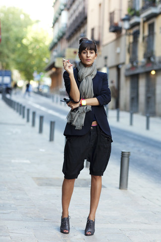 dunkelblaues Sakko, schwarze Bermuda-Shorts, schwarze Schnürstiefeletten aus Leder mit Ausschnitten, grauer Schal für Damen