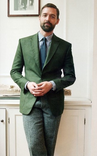 Patrick Grant trägt dunkelgrünes Sakko, weißes und dunkelblaues Businesshemd mit Vichy-Muster, dunkelgrüne Wollanzughose, dunkelblaue Krawatte