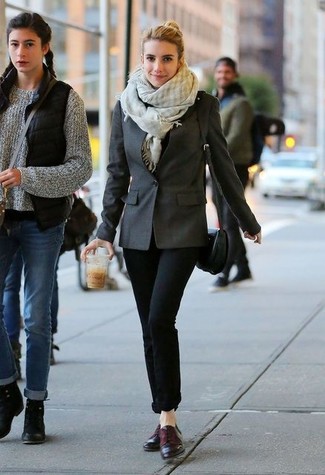 Emma Roberts trägt dunkelgraues Sakko, schwarze enge Jeans, dunkellila Leder Derby Schuhe, schwarze Leder Umhängetasche
