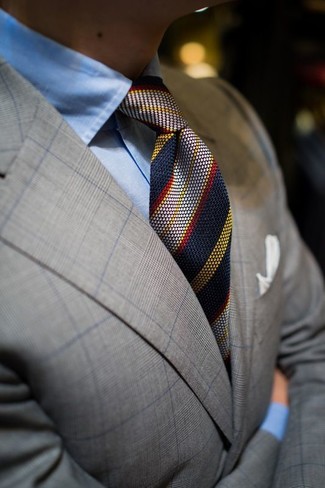 graues Sakko mit Schottenmuster, hellblaues Businesshemd, dunkelblaue vertikal gestreifte Krawatte, weißes Einstecktuch für Herren