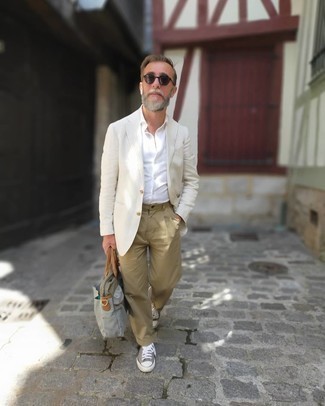 50 Jährige: Weißes Hemd kombinieren – 500+ Herren Outfits: Vereinigen Sie ein weißes Hemd mit einer beige Chinohose, um mühelos alles zu meistern, was auch immer der Tag bringen mag. Graue Segeltuch niedrige Sneakers bringen Eleganz zu einem ansonsten schlichten Look.