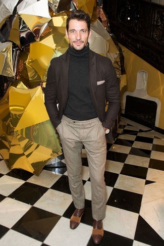 David Gandy trägt dunkelbraunes Wollsakko, schwarzer Rollkragenpullover, hellbeige Wollanzughose, dunkelbraune Leder Oxford Schuhe