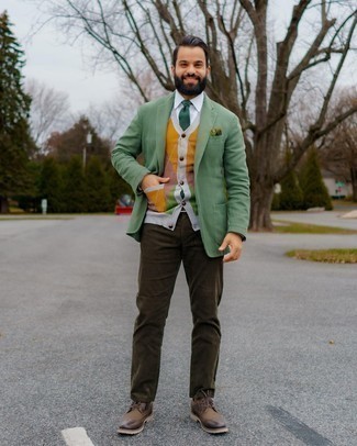 grünes Sakko, mehrfarbige Strickjacke mit Argyle-Muster, weißes Businesshemd, dunkelbraune Jeans für Herren