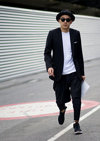 schwarzes Sakko, weißes T-Shirt mit einem Rundhalsausschnitt, schwarze Chinohose, schwarze Sportschuhe für Herren