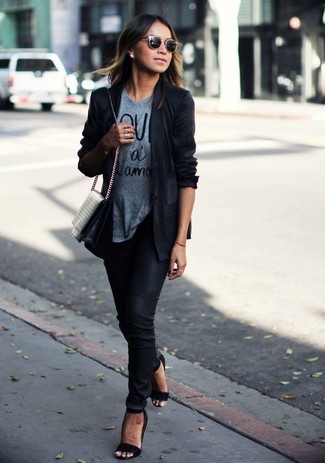 schwarzes Sakko, graues bedrucktes T-Shirt mit einem Rundhalsausschnitt, schwarze enge Hose, schwarze Leder Sandaletten für Damen