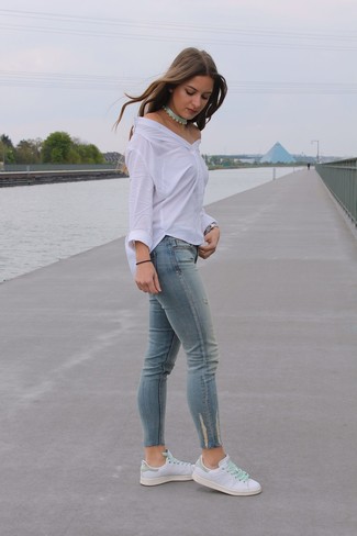 Hellblaue Jeans kombinieren – 948+ Damen Outfits: Entscheiden Sie sich für einen mühelosen lässigen City-Look in einem weißen schulterfreiem Oberteil und hellblauen Jeans. Ergänzen Sie Ihr Look mit weißen Leder niedrigen Sneakers.