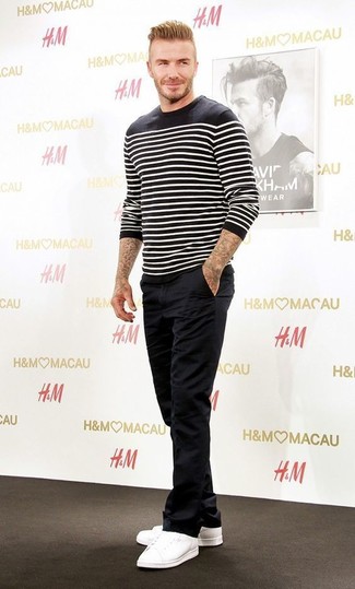 David Beckham trägt schwarzer und weißer horizontal gestreifter Pullover mit einem Rundhalsausschnitt, schwarze Chinohose, weiße niedrige Sneakers