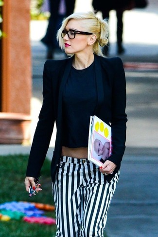 Gwen Stefani trägt schwarzes Sakko, schwarzes kurzes Oberteil, weiße und schwarze vertikal gestreifte Jeans