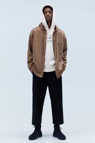 braune Shirtjacke, weißer und schwarzer bedruckter Pullover mit einem Kapuze, schwarze Chinohose, schwarze hohe Sneakers aus Segeltuch für Herren