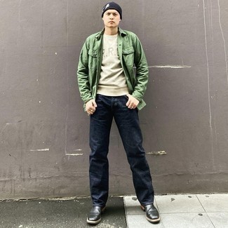 grüne Shirtjacke, graues bedrucktes Sweatshirt, dunkelblaue Jeans, schwarze Chelsea Boots aus Leder für Herren
