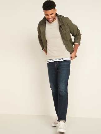 Hellbeige Pullover kombinieren – 1200+ Herren Outfits: Vereinigen Sie einen hellbeige Pullover mit dunkelblauen Jeans für ein bequemes Outfit, das außerdem gut zusammen passt. Weiße Segeltuch niedrige Sneakers putzen umgehend selbst den bequemsten Look heraus.