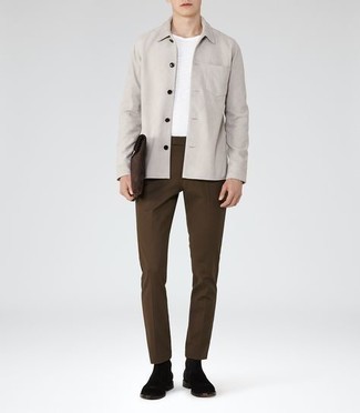 graue Shirtjacke, weißes T-Shirt mit einem Rundhalsausschnitt, dunkelbraune Chinohose, schwarze Chelsea Boots aus Wildleder für Herren
