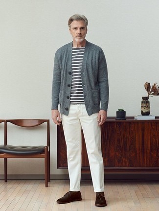 Herren Outfits 2022: Kombinieren Sie eine graue Strickjacke mit einer weißen Chinohose für ein Alltagsoutfit, das Charakter und Persönlichkeit ausstrahlt. Dunkelbraune Chukka-Stiefel aus Wildleder sind eine großartige Wahl, um dieses Outfit zu vervollständigen.