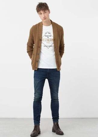 braune Strickjacke mit einem Schalkragen, weißes bedrucktes T-Shirt mit einem Rundhalsausschnitt, dunkelblaue enge Jeans, dunkelbraune Lederfreizeitstiefel für Herren