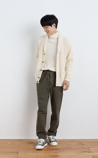 Teenager: Dunkelgrüne Hose kombinieren – 132 Herren Outfits: Kombinieren Sie eine hellbeige Strickjacke mit einem Schalkragen mit einer dunkelgrünen Hose für einen für die Arbeit geeigneten Look. Putzen Sie Ihr Outfit mit grauen Segeltuch niedrigen Sneakers.