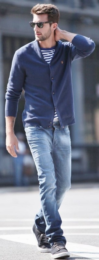 dunkelblaue Strickjacke mit einem Schalkragen, weißes und blaues horizontal gestreiftes T-Shirt mit einem Rundhalsausschnitt, blaue Jeans, dunkelgraue Leinenschuhe für Herren