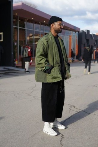 olivgrüne Strickjacke mit einer offenen Front, schwarzer Pullover mit einem Rundhalsausschnitt, schwarze Chinohose, weiße hohe Sneakers aus Segeltuch für Herren