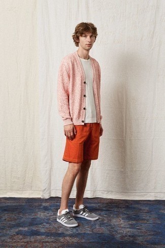 Orange Shorts kombinieren – 133 Herren Outfits: Kombinieren Sie eine rosa Strickjacke mit orange Shorts für ein bequemes Outfit, das außerdem gut zusammen passt. Graue Wildleder niedrige Sneakers verleihen einem klassischen Look eine neue Dimension.